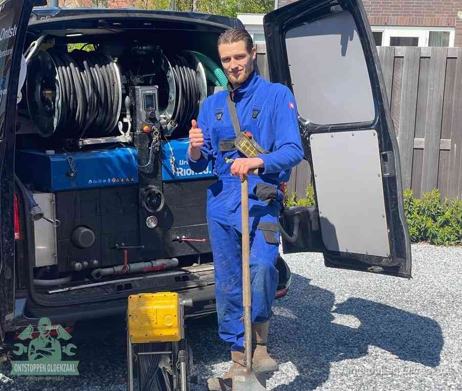 Een tevreden monteur met opgestoken duim naast de bestelbus, slim en snel ingrijpen bespaart geld bij een verstopping in Oldenzaal