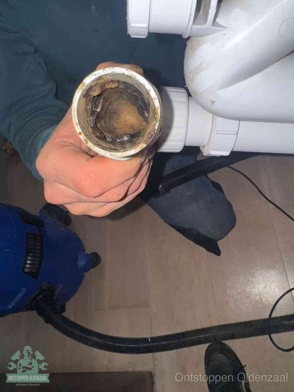 Een losgekoppeld afvoerbuisstuk dat van binnen volledig is dichtgeslibd, het gevolg van een verstopping te lang laten zitten in Oldenzaal