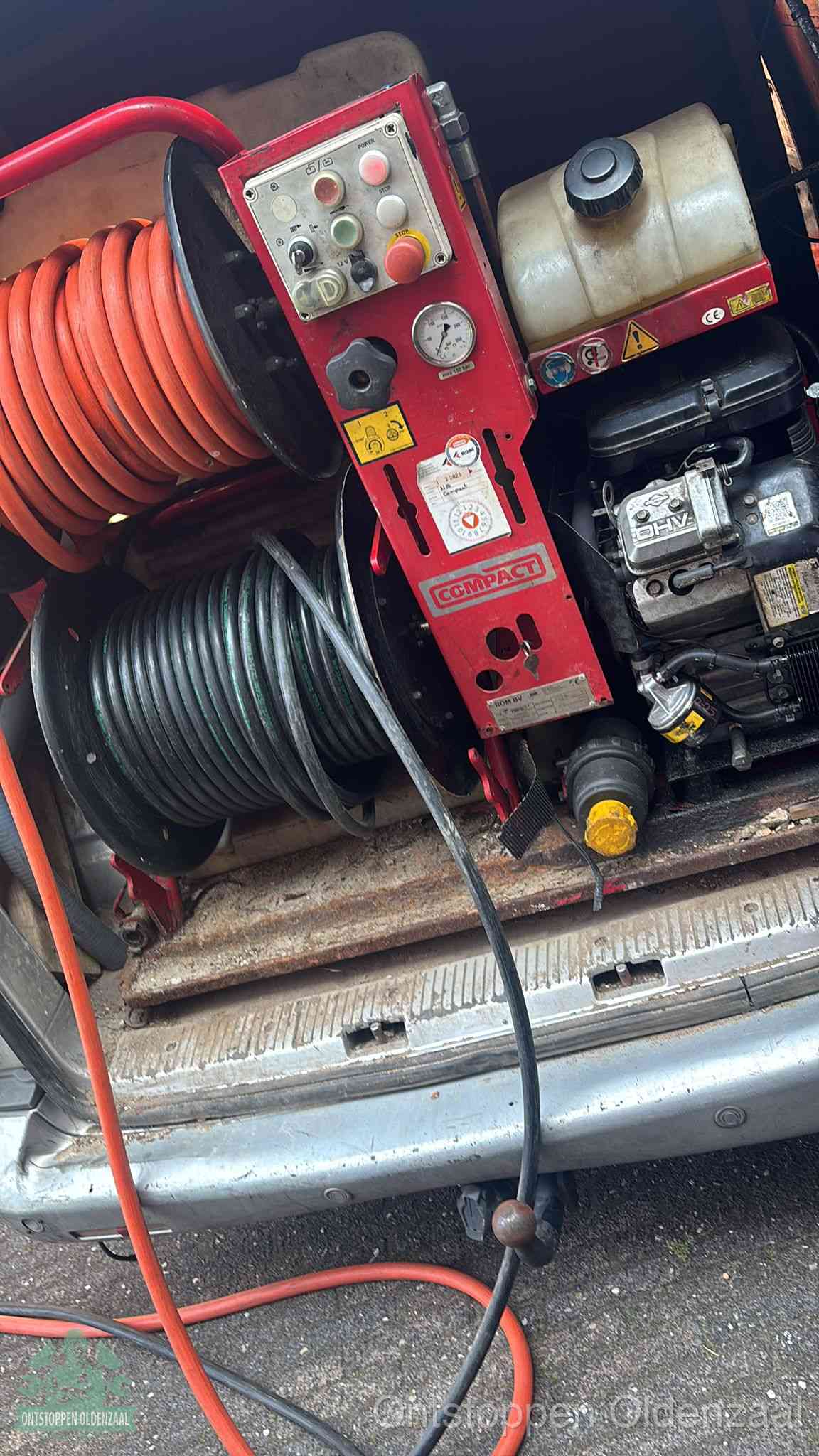 Een rood hogedruk-rioolreinigingstoestel met slangen in de laadbak van de bedrijfsbus, apparatuur voor een hardnekkige wc-verstopping in Oldenzaal