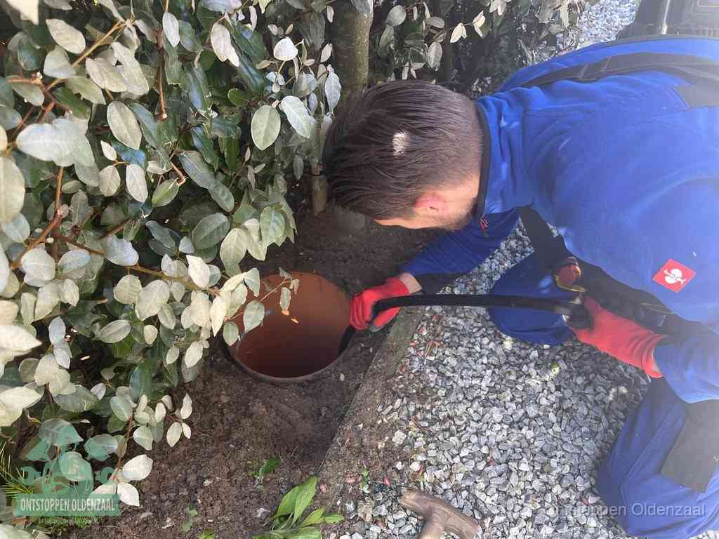Monteur reinigt een rioolput met een slang, periodieke rioolreiniging in Oldenzaal