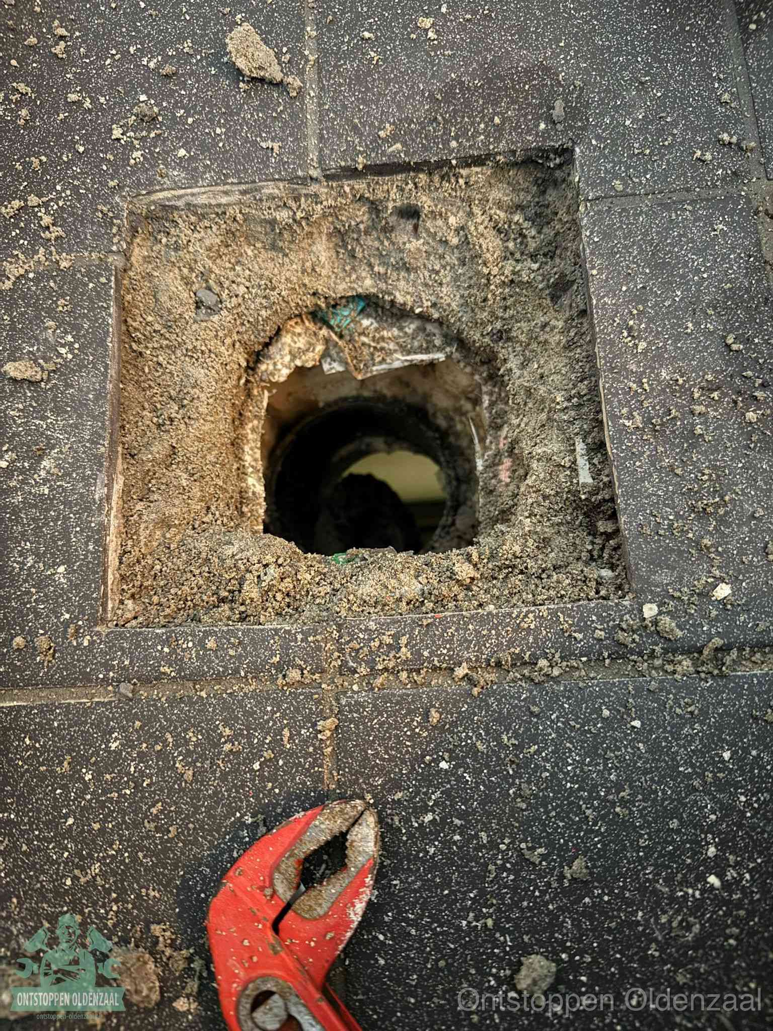 Geopend rioolputje op de erfgrens dat laat zien wie eigenaar is van de riolering in Oldenzaal