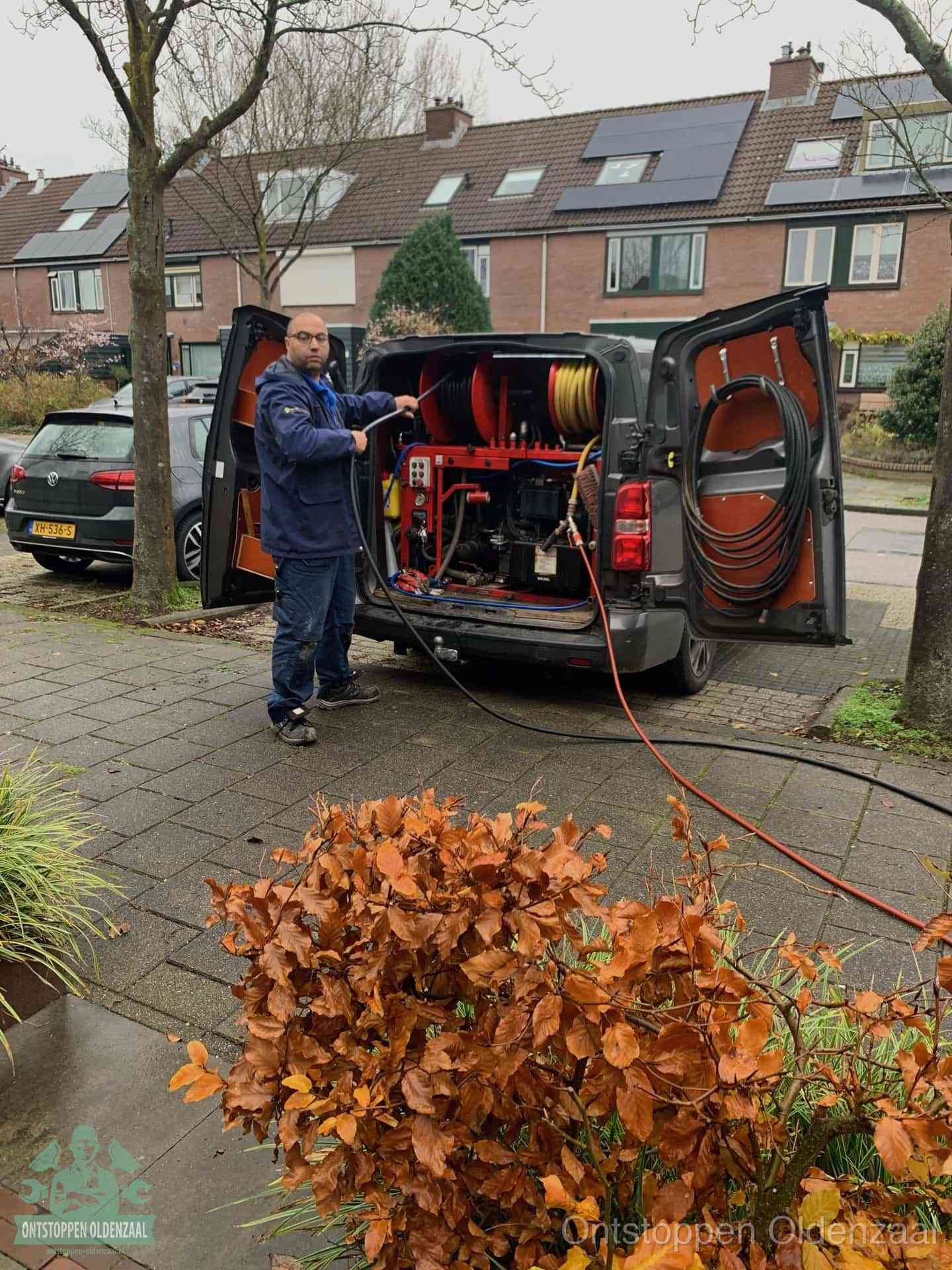Monteur met rioolreinigingsbus levert rioolservice in de wijk in Oldenzaal