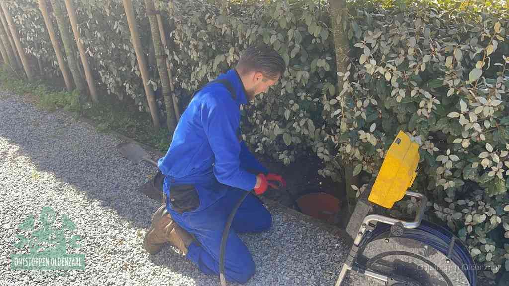 Monteur aan het werk bij een rioolput, de werkwijze voor riool ontstoppen in Oldenzaal